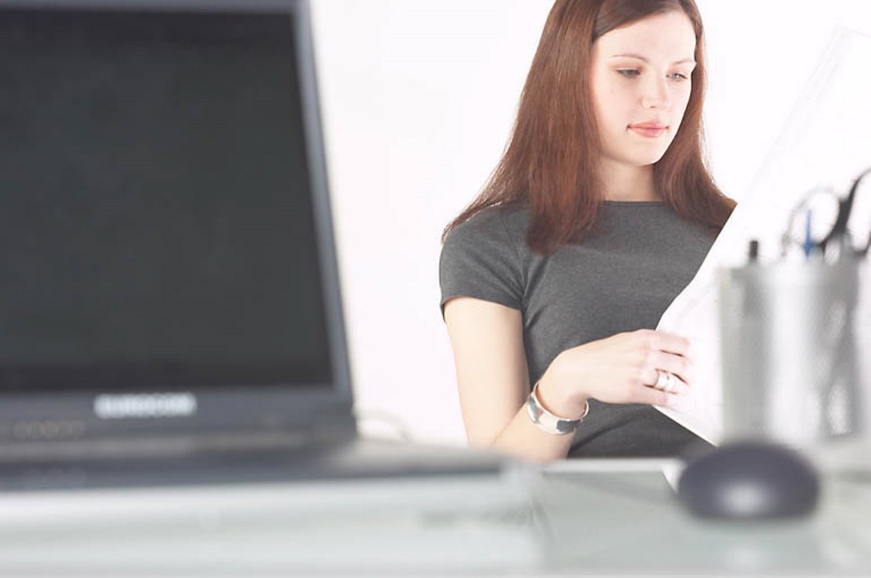 Woman reading newspaper at her desk uid 1271427.jpg